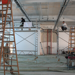 Busy men lay cables and pipes in the new machine hall.